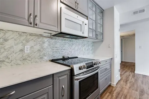 a kitchen with granite countertop cabinets stainless steel appliances and wooden floor