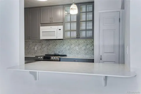 a kitchen with white cabinets and window