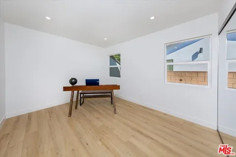 a bedroom with a bed furniture potted plant and a window