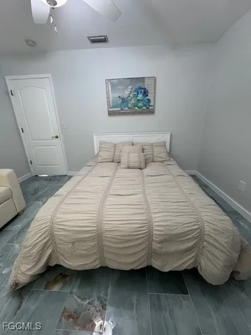 a bedroom with a bed next to a wooden floor