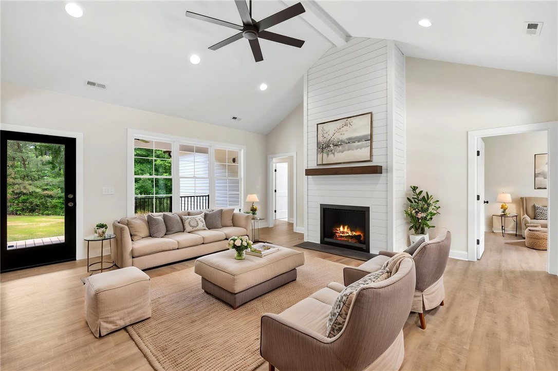 1735 Maw Bridge Road Central, SC 29630 - Photo 9 of 42 A spacious great room features soaring vaulted ceilings, warm hardwood flooring, and a cozy fireplace centerpiece.
