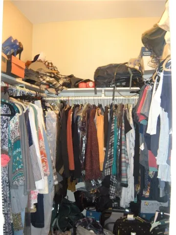 a view of walk in closet with clothes and shoes