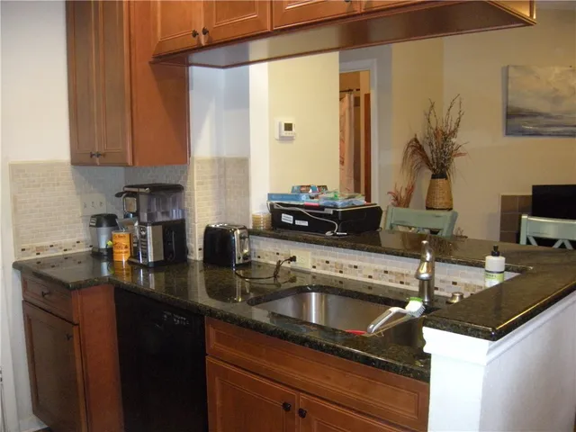 a kitchen with granite countertop a sink and cabinets