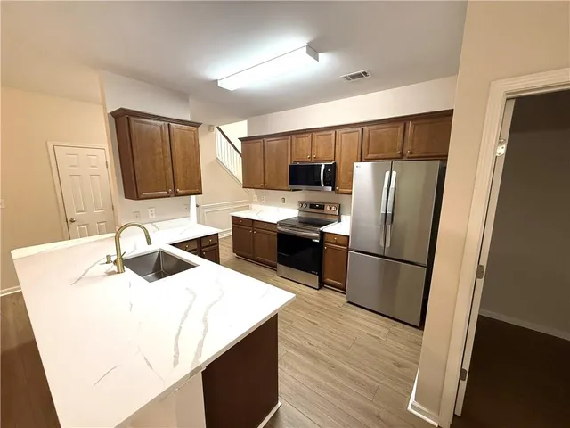 a kitchen with stainless steel appliances a refrigerator stove microwave and sink