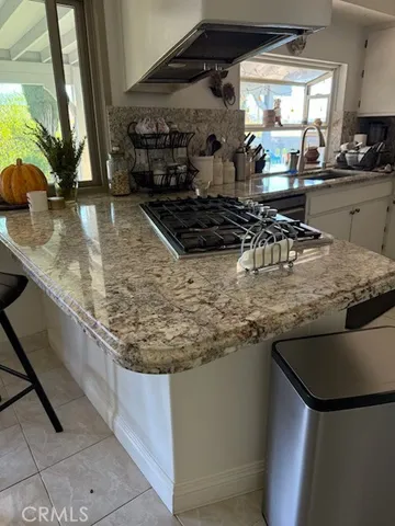 a kitchen with kitchen island granite countertop a sink a counter top space and cabinets