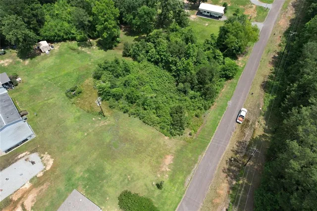 an aerial view of residential house with outdoor space and trees all around