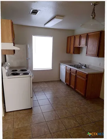 a kitchen with stainless steel appliances a stove a sink and a refrigerator