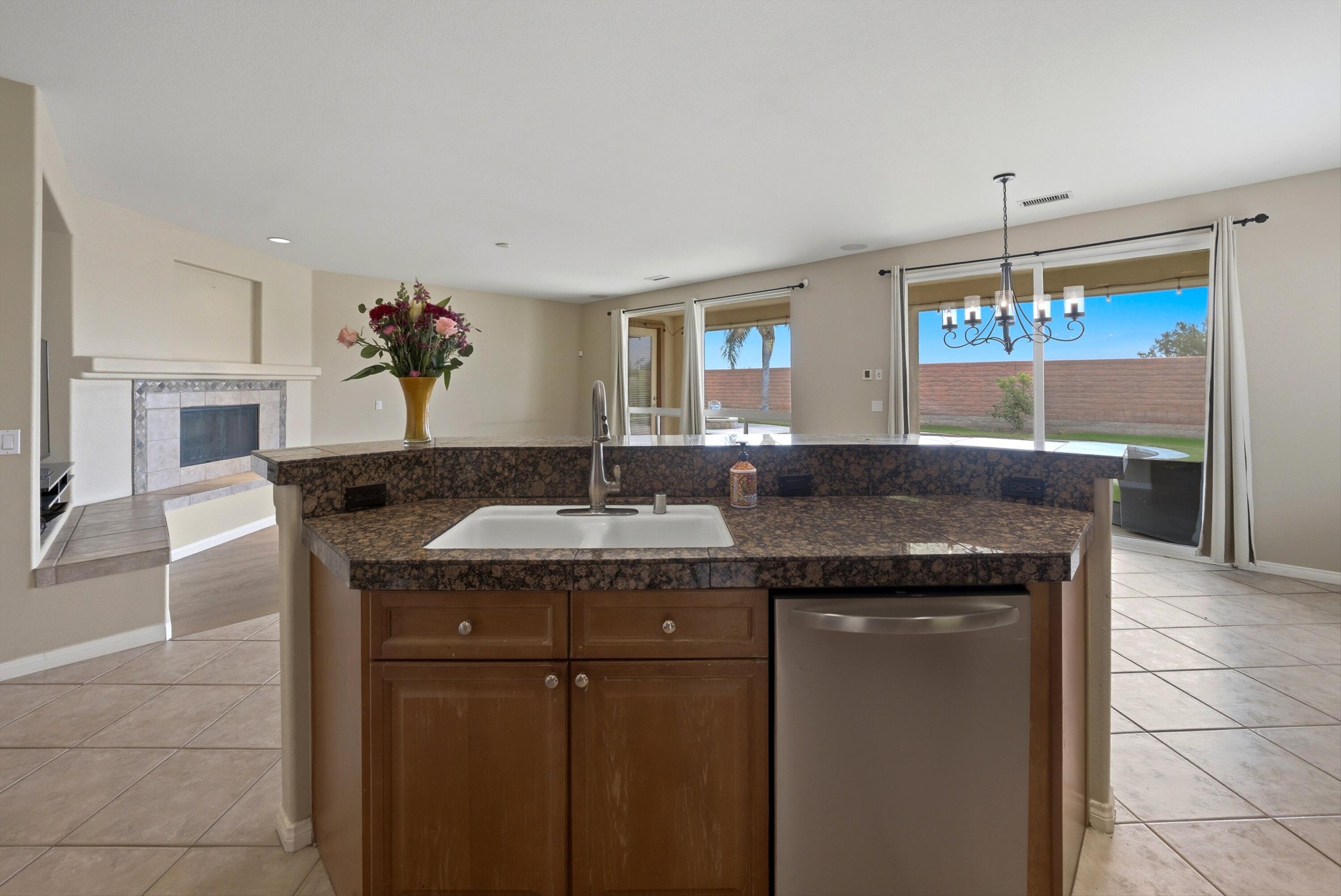 232 Via Firenza Rancho Mirage, CA 92270 - Photo 14 of 43 a kitchen with a granite counter top a sink stainless steel appliances and window