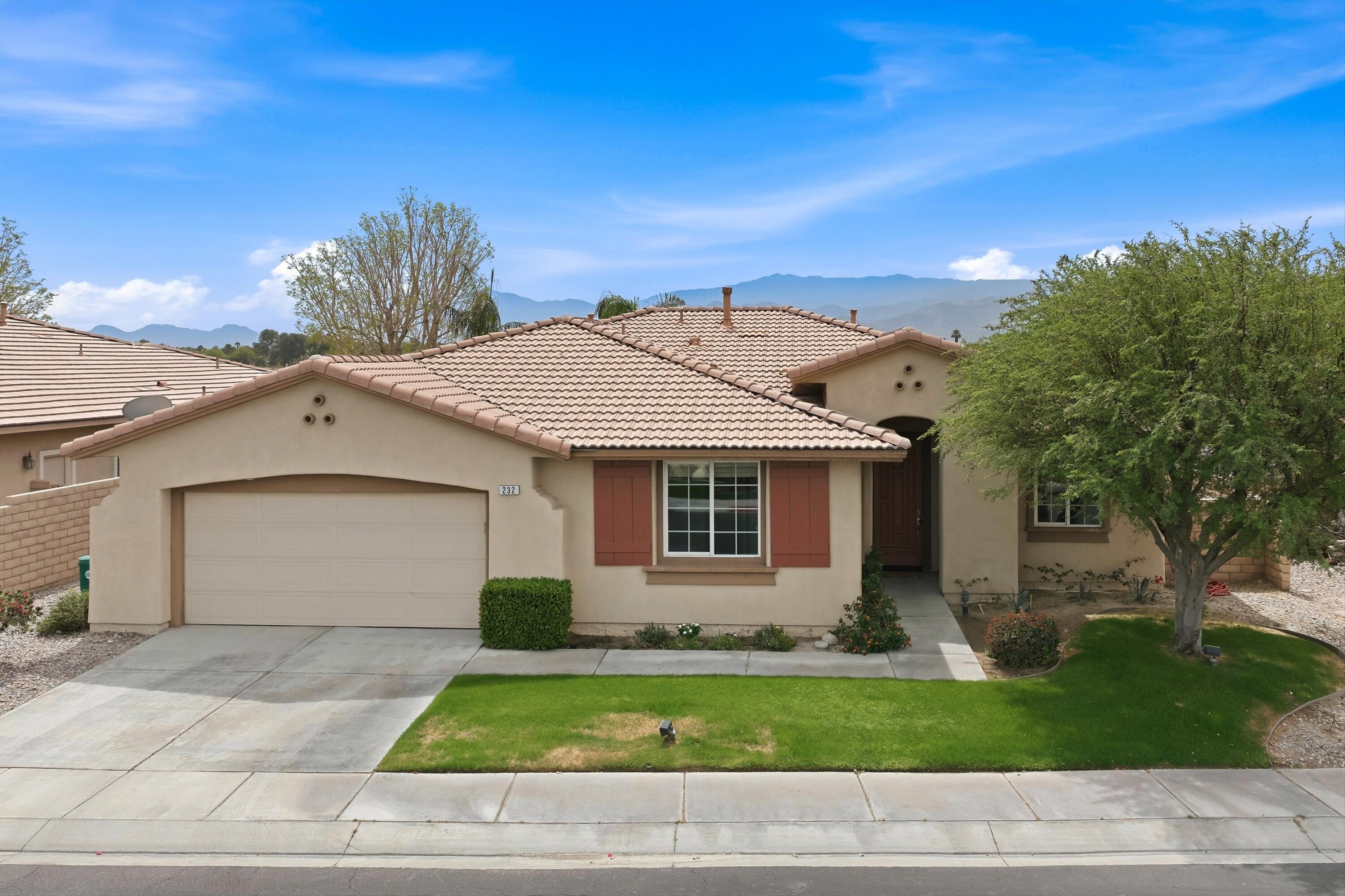 232 Via Firenza Rancho Mirage, CA 92270 - Photo 2 of 43 a front view of a house with a yard and garage