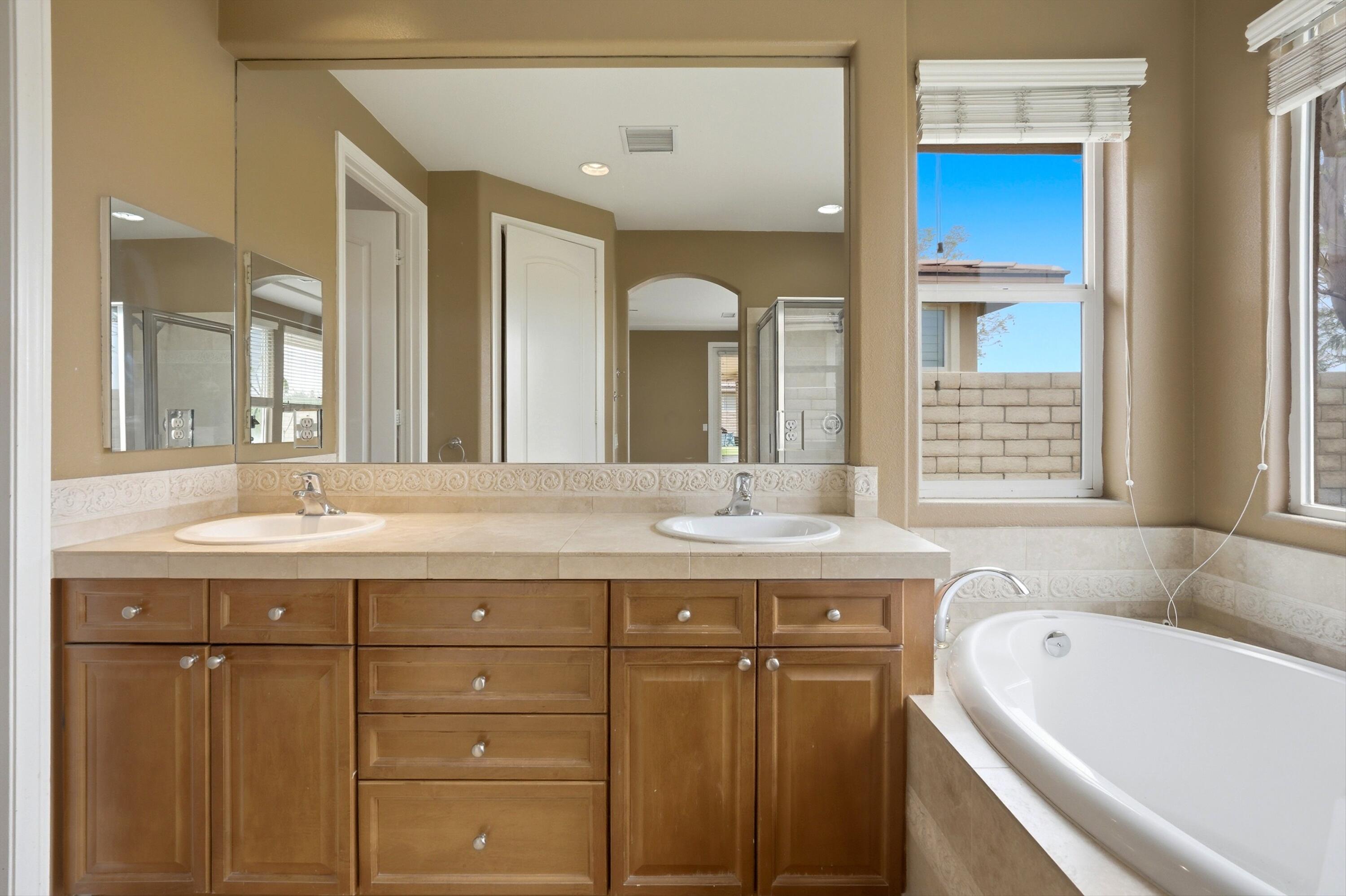 232 Via Firenza Rancho Mirage, CA 92270 - Photo 24 of 43 a bathroom with a tub a double vanity sink and mirror