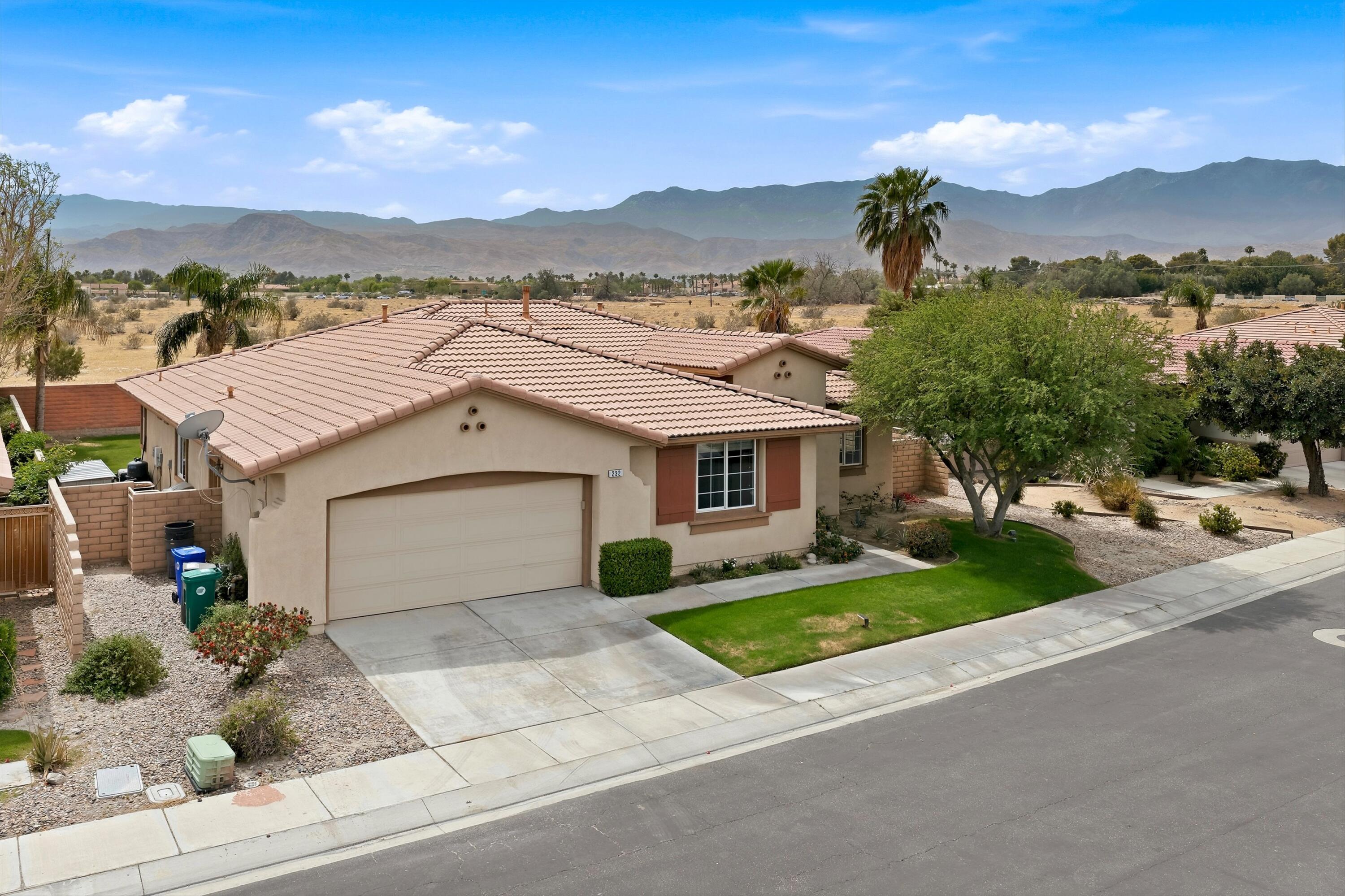 232 Via Firenza Rancho Mirage, CA 92270 - Photo 3 of 43 a front view of a house with a yard and garage