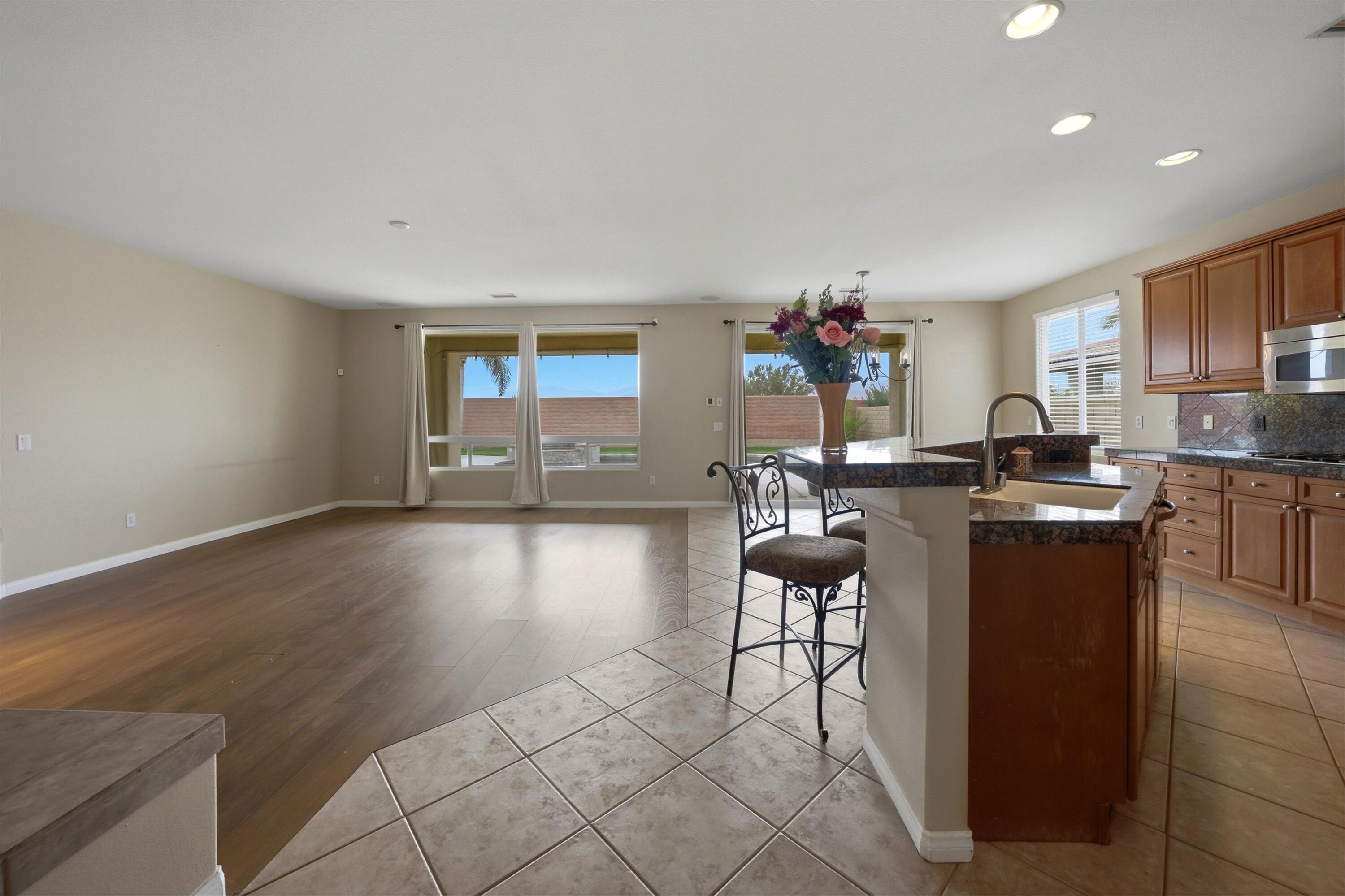 232 Via Firenza Rancho Mirage, CA 92270 - Photo 7 of 43 a living room with couches and kitchen view with wooden floor