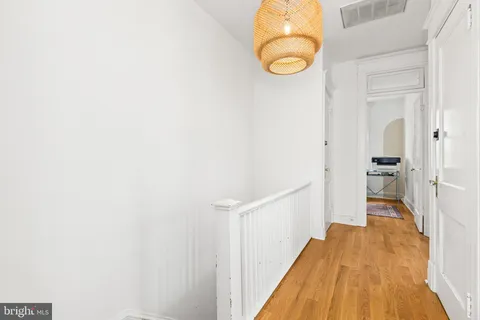 a view of a hallway with wooden floor and staircase