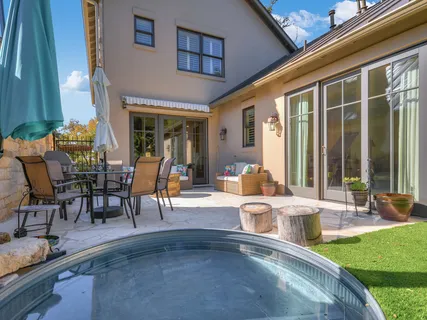 a view of a patio with dining table and chairs with plants