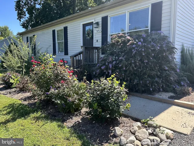 a front view of a house with a yard and garden