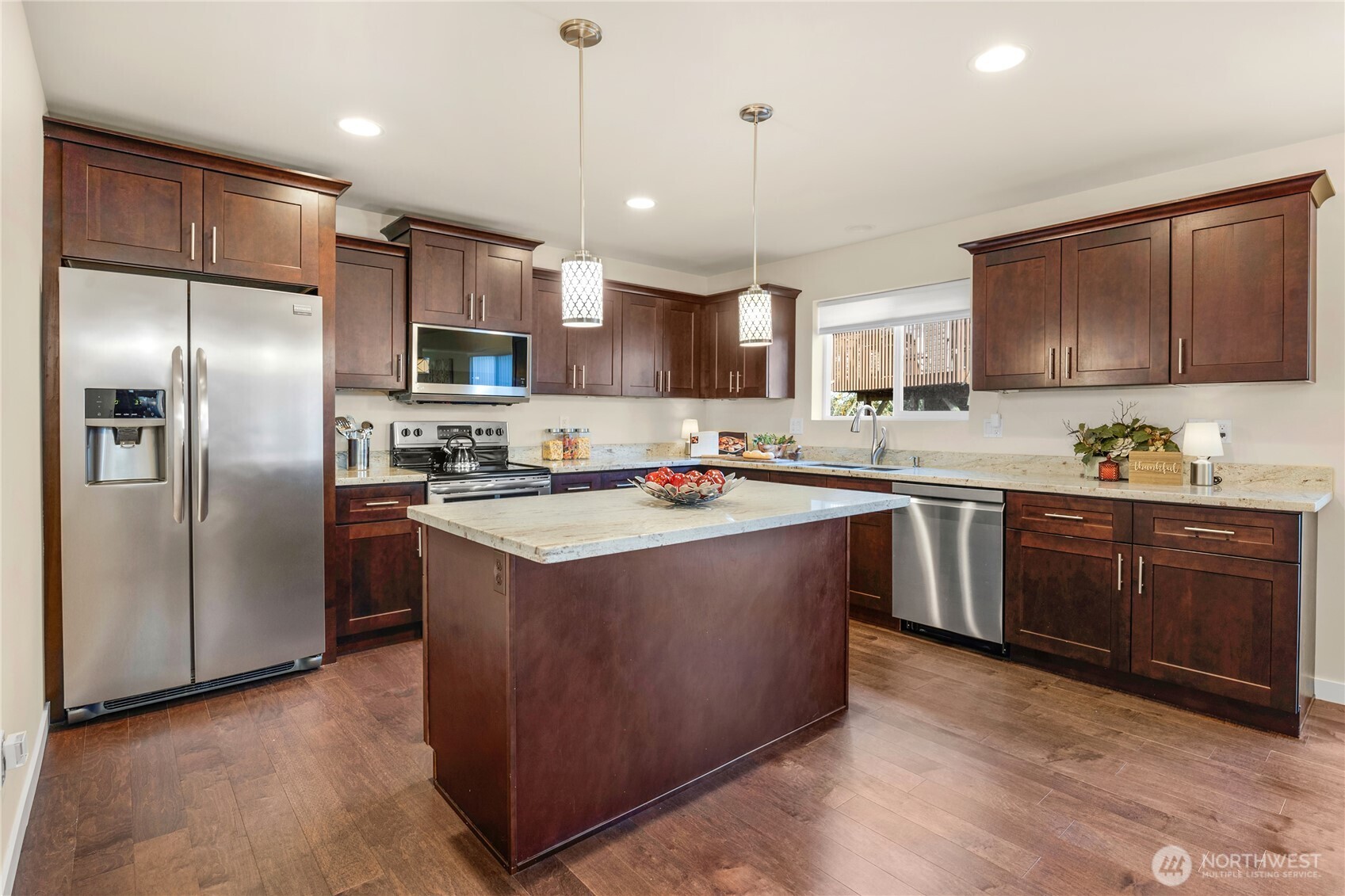 10034 59th Avenue South Seattle, WA 98178 - Photo 13 of 39 a kitchen with stainless steel appliances granite countertop a refrigerator a sink a stove a microwave and wooden floors