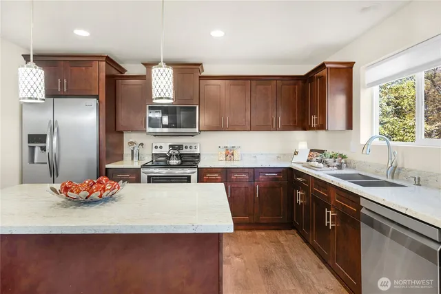 a kitchen with stainless steel appliances granite countertop a sink refrigerator and microwave
