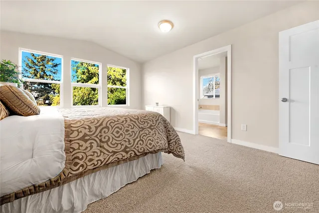 a large bed sitting in a bedroom next to a window