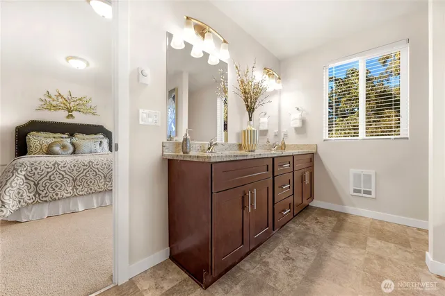 a bathroom with a double vanity sink a mirror and a bathtub