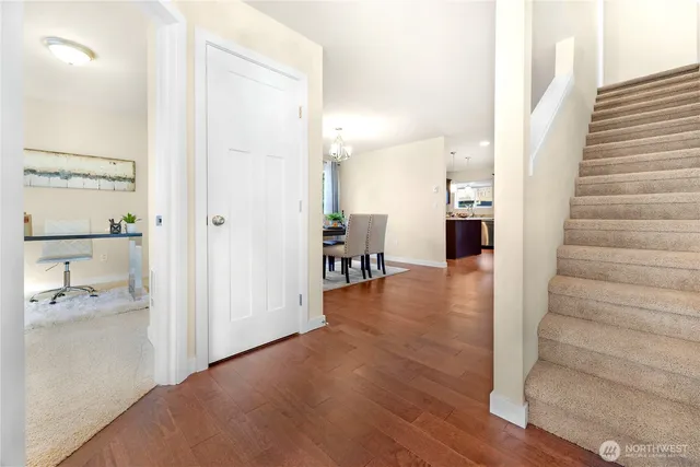 a view of a hallway view with wooden floor and a bathroom