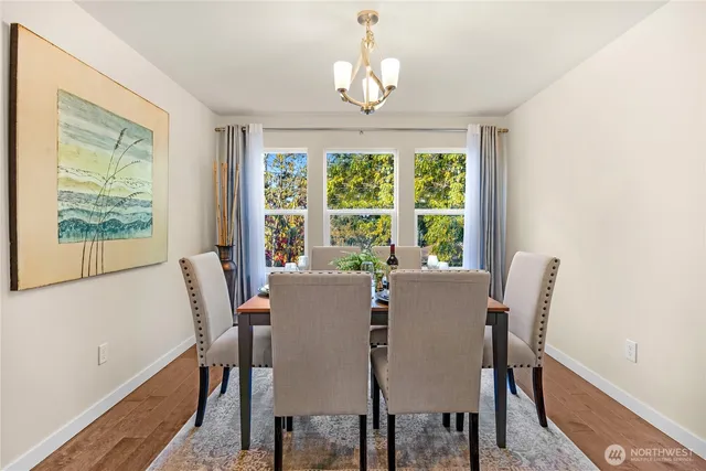 a view of a dining room with furniture a chandelier and wooden floor