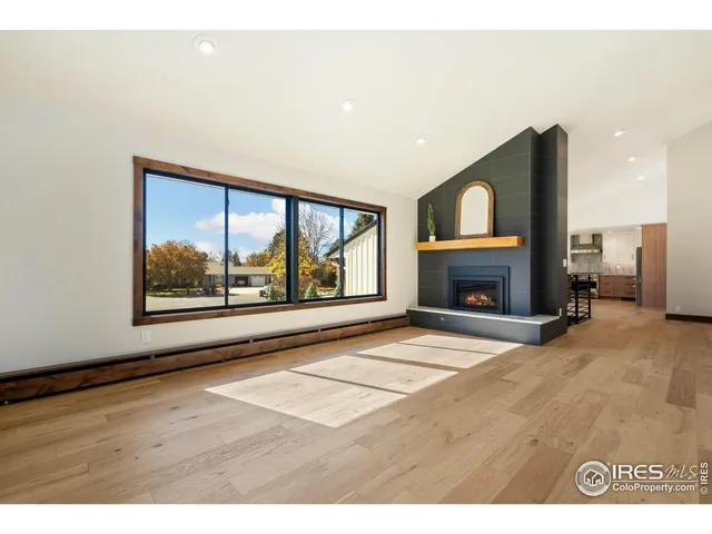 a view of an empty room with a fireplace and a window