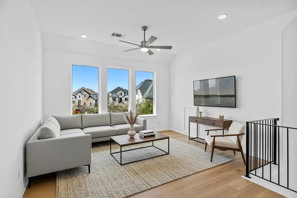 a living room with furniture a flat screen tv and a chandelier
