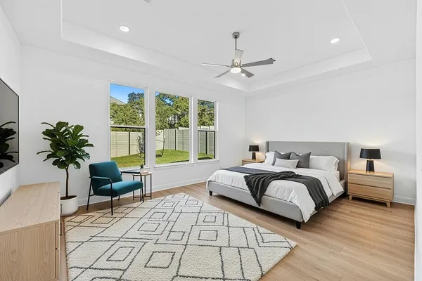 a spacious bedroom with a bed a couch and a potted plant