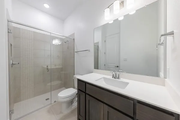 a bathroom with a sink a toilet and shower