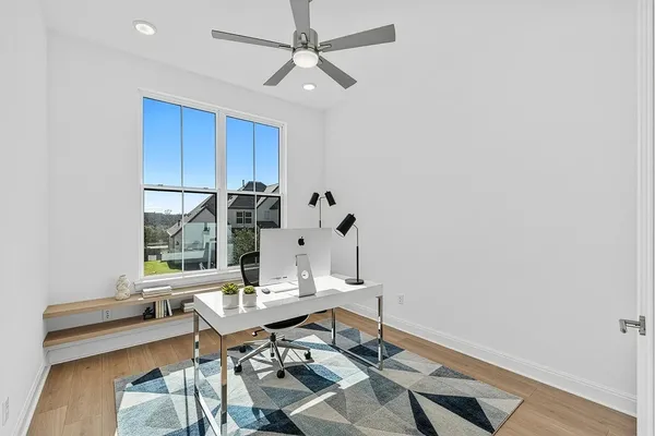 a view of a workspace with furniture and wooden floor