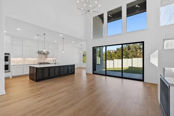 a view of an empty room with wooden floor and a large window