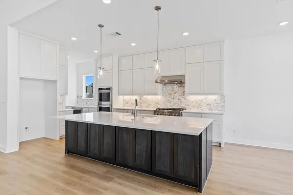 a kitchen with kitchen island a sink stainless steel appliances and cabinets