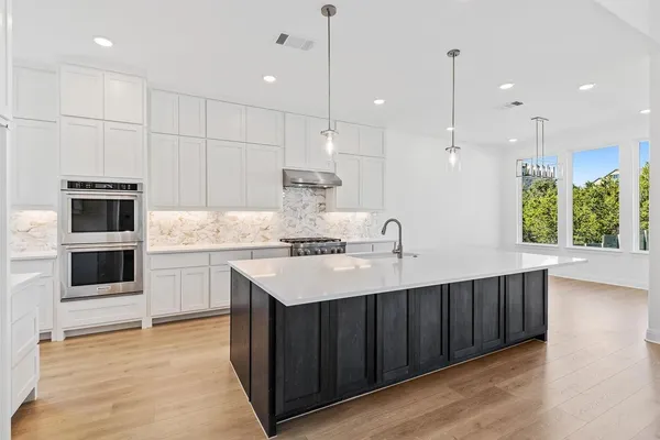 a kitchen with stainless steel appliances kitchen island a large island in the center