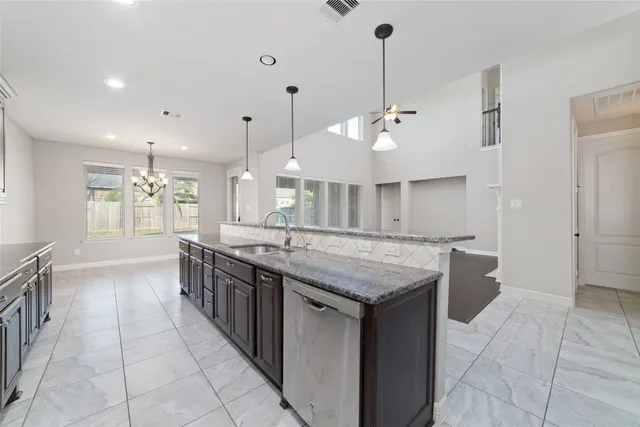 a kitchen with stainless steel appliances granite countertop a sink and a refrigerator