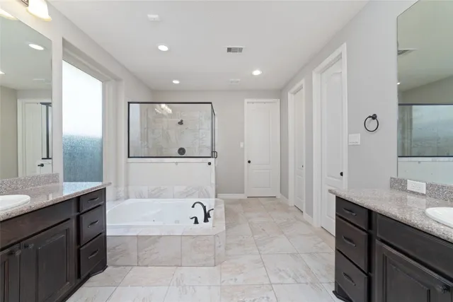 a bathroom with a tub sink and mirror