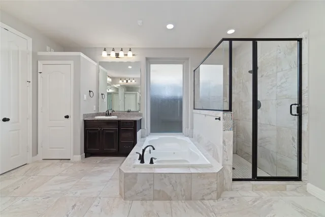 a bathroom with a tub shower and sink