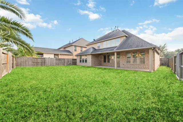 a view of a house with a big yard plants and large trees