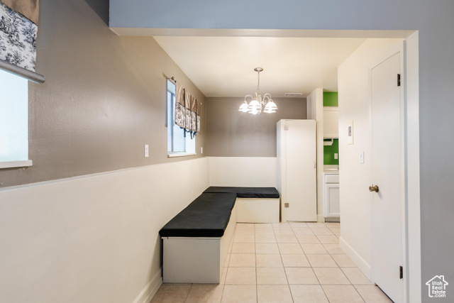 167 East 100 North, Unit B Logan, UT 84321 - Photo 3 of 18 Hallway with light tile patterned floors and a chandelier