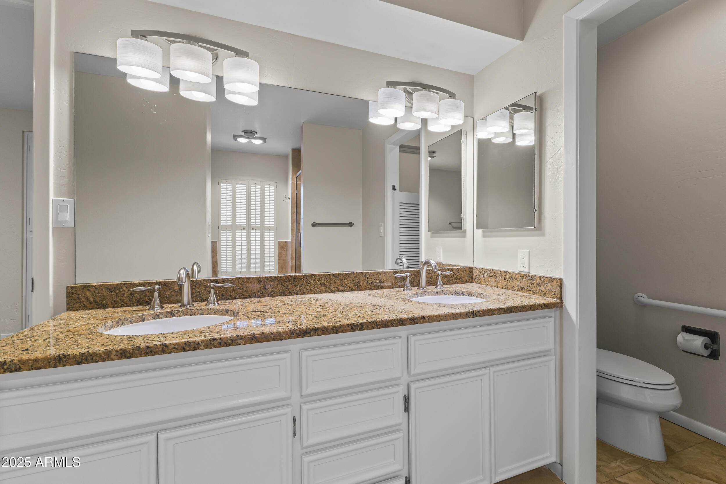 6835 North 1st Place Phoenix, AZ 85012 - Photo 11 of 42 a bathroom with a granite countertop sink a toilet and a mirror