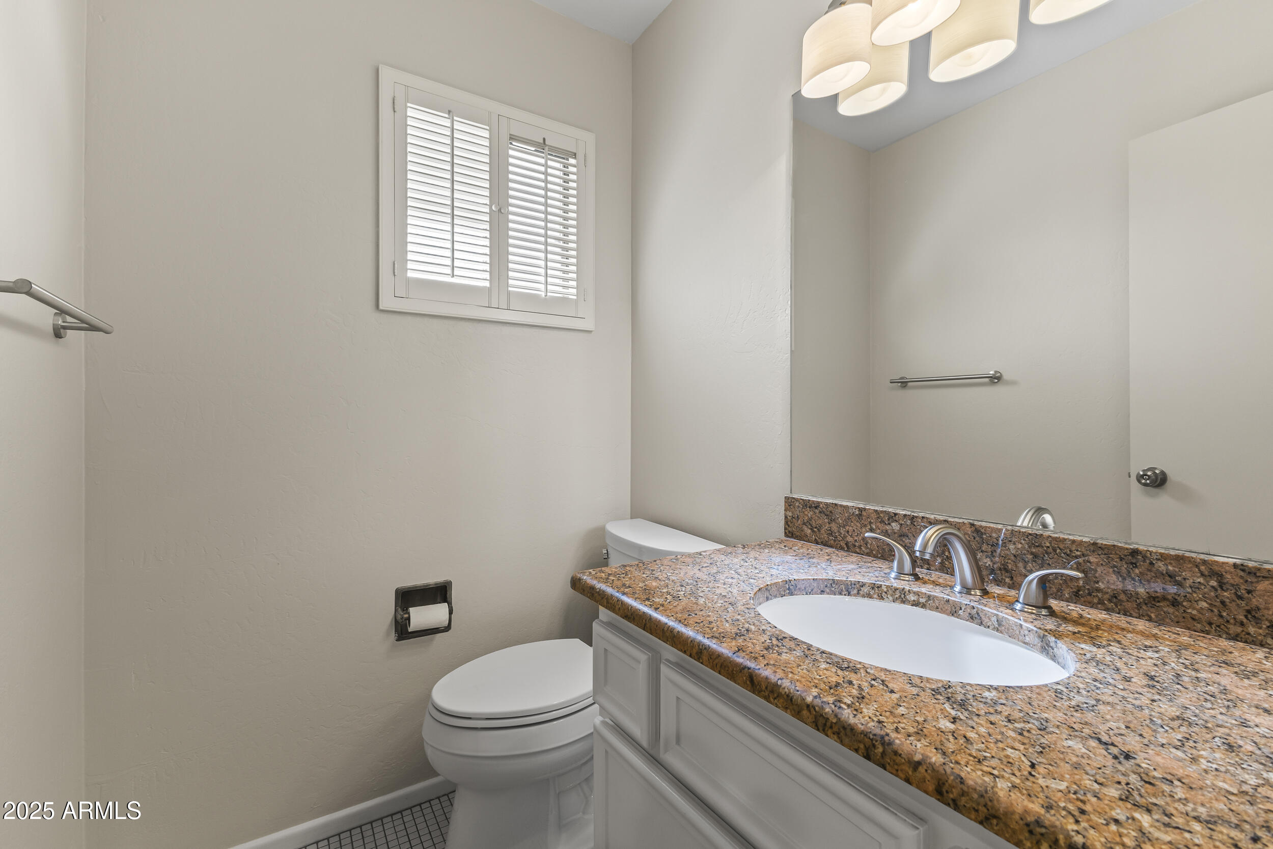 6835 North 1st Place Phoenix, AZ 85012 - Photo 15 of 42 a bathroom with a granite countertop sink a mirror and a toilet