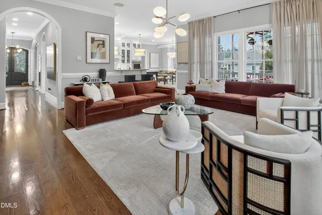 a living room with furniture a rug potted plant and a window