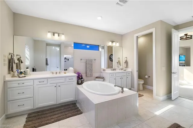 a bathroom with a tub a sink and mirrors