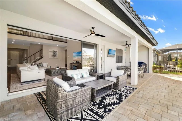 a view of swimming pool with lawn chairs and iron fence