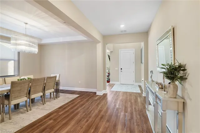 a view of a hallway with wooden floor and furniture