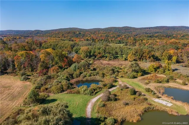 an aerial view of residential house with outdoor space and trees all around