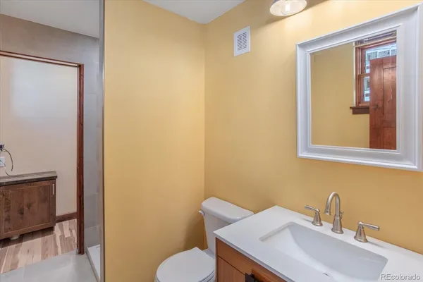 a bathroom with a sink mirror and toilet