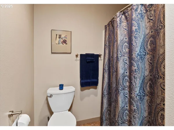 a bathroom with a toilet and a shower curtain