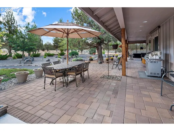a view of a patio with a table and chairs under an umbrella