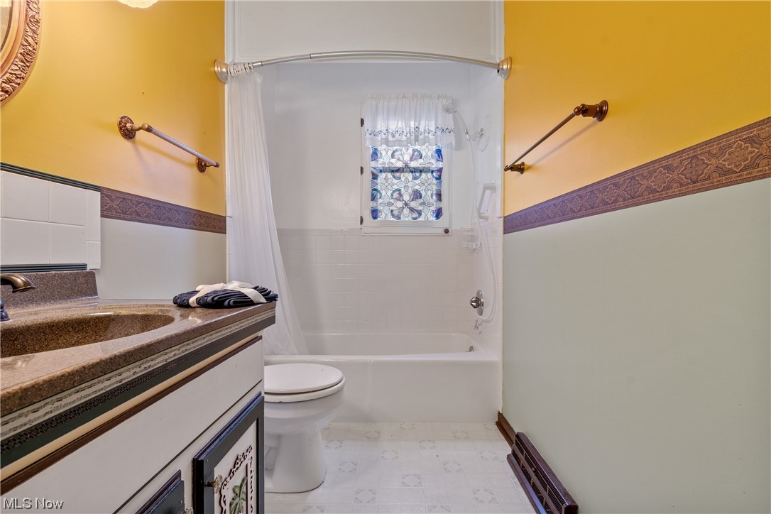 41 Willard Street Rittman, OH 44270 - Photo 13 of 25 Full bathroom with oversized vanity, tile floors, shower / bath combination with curtain, and toilet