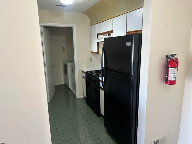 a kitchen with refrigerator and cabinets